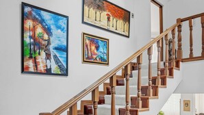 Un escalier avec des rampes et une main courante en bois, menant à l’étage supérieur.