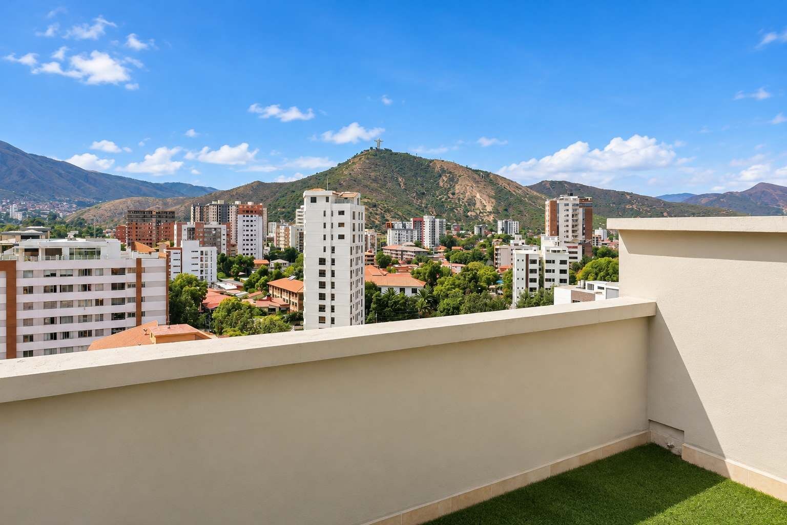 A residential area with modern buildings, a clear sky, and a distant mountain.