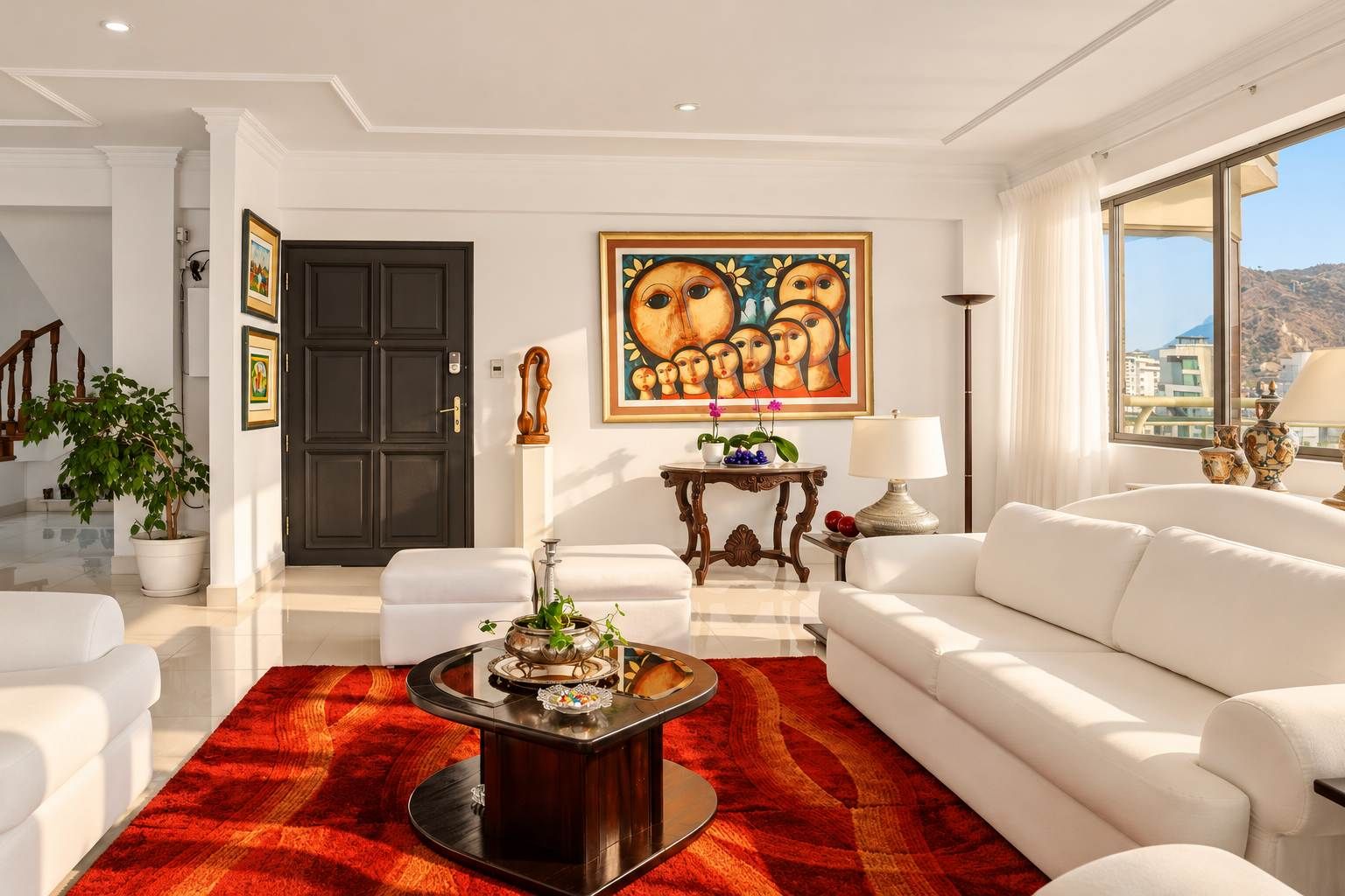 A modern living room with a white sofa, a red rug, a coffee table, and a painting on the wall.