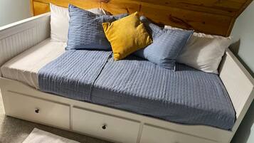 A bed with a headboard, pillows, and a blanket.
