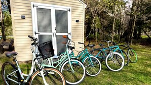 Varias bicicletas están estacionadas frente a una casa con puerta y ventanas.