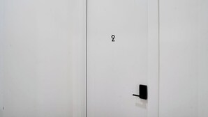 Une porte blanche dotée d’un clavier numérique et d’une petite poignée noire.