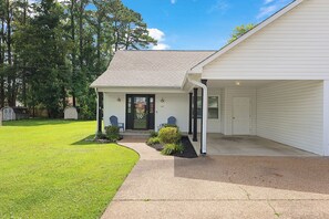 A single-story house with a front porch, a garage, and a well-maintained lawn.