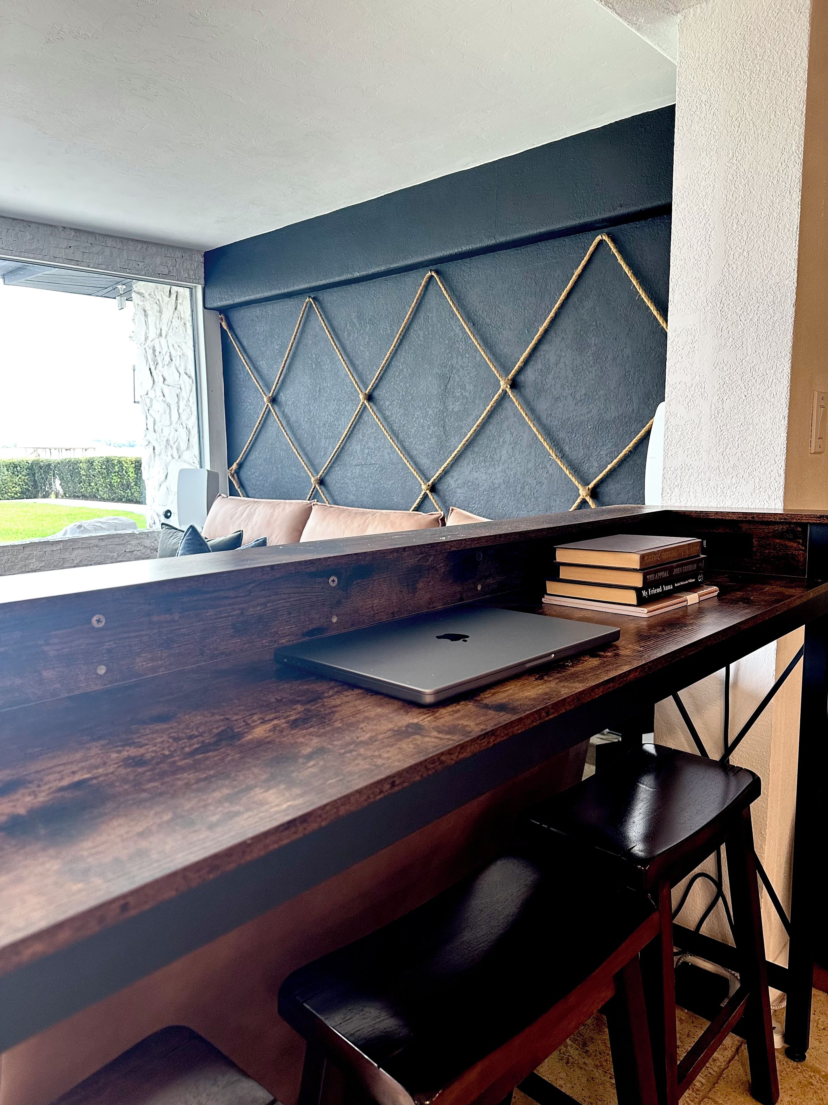 Ein moderner Arbeitsplatz mit einem Holztisch, einem Laptop und Büchern.