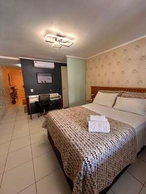 Ein Hotelzimmer mit einem Bett, einem Schreibtisch und einem Stuhl.