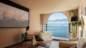 A room with a large window, a painting, a sofa, a coffee table, and a chair. - Dali Azure Hillside Boutique Resort- Wenbi Village - Gourmet Dining & Cocktail Lounge & Complimentary Airport Pick-up for 2 Nights (Dali)