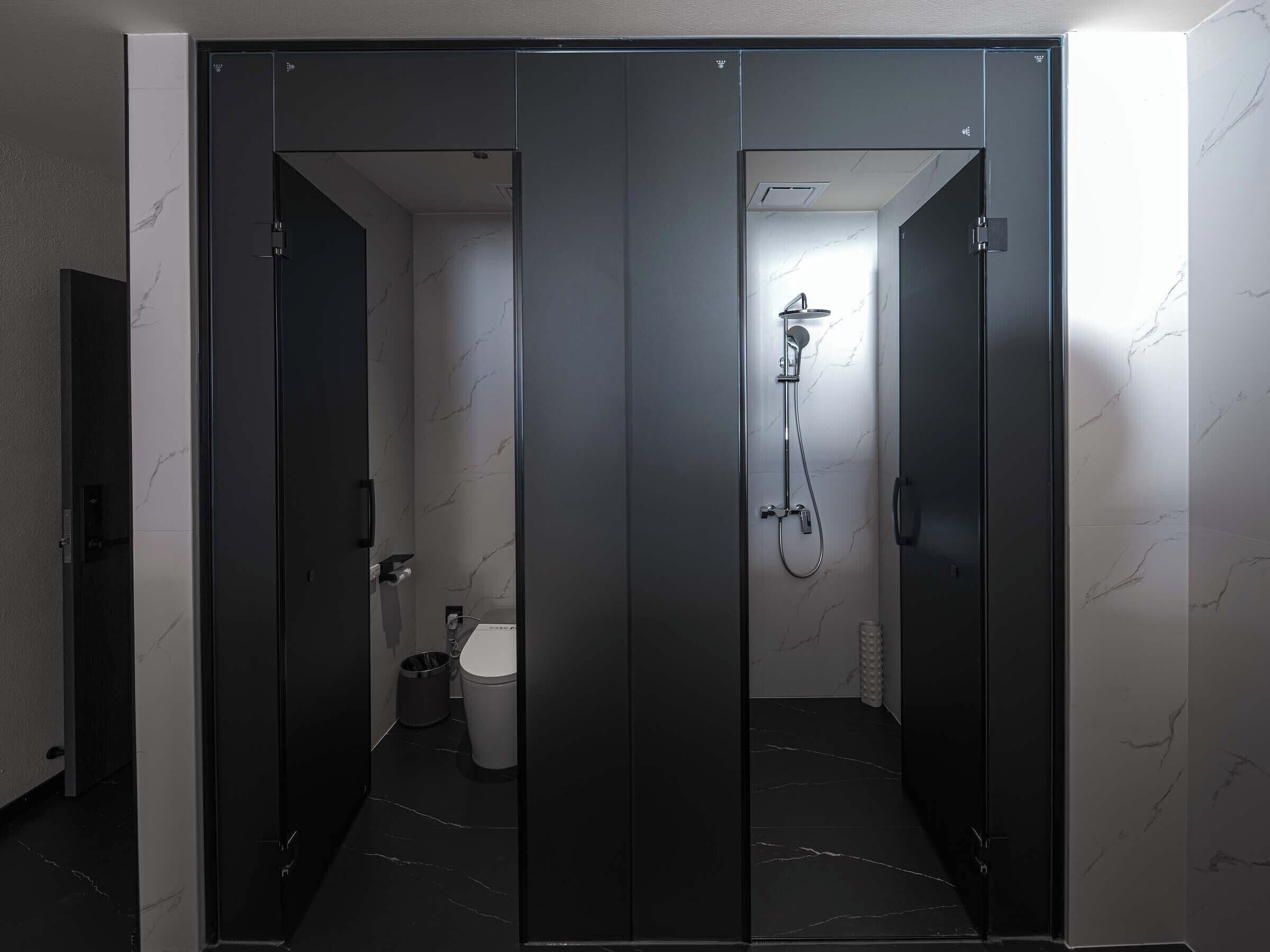 A modern bathroom with a shower, toilet, and sink.