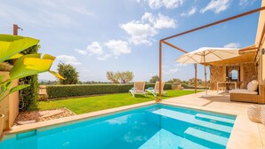 Ein Schwimmbad mit Liegestühlen und einer Terrasse.