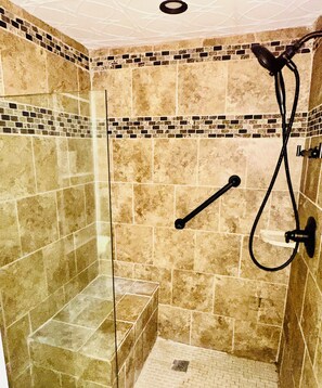 A shower with a glass door, tiled walls, and a handheld showerhead. - Unique 3-bedroom 2 bathroom house with enclosed porch in charming Stockbridge (Stockbridge)