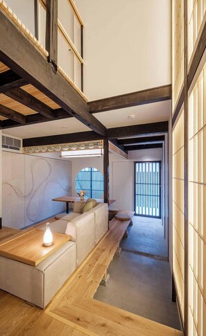 A traditional Japanese interior with tatami flooring, a low wooden table, and a sliding door. - Wakaba Machiya House (Kyoto)