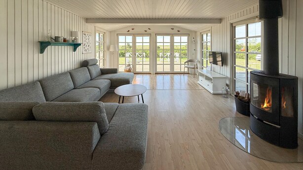 A living room with a sofa, a small table, a fireplace, and a TV. - Awesome home in Rødby with WiFi (Rødby)