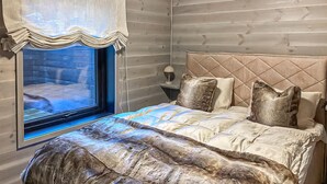 A bedroom with a bed, pillows, a nightstand, a lamp, and a window with a curtain. - Awesome home in Tjørhom with sauna (Tjørhom)