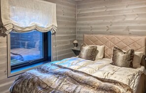 A bedroom with a bed, pillows, a nightstand, a lamp, and a window with a curtain. - Awesome home in Tjørhom with sauna (Tjørhom)