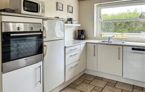 Eine Küche mit Backofen von Bosch, einer Mikrowelle, einem Kühlschrank, einer Kaffeemaschine und einem Geschirrspüler.