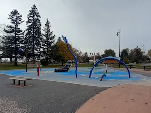 A playground with blue and red equipment, a bench, and a sign that reads 'PORT DARLINGTON.'