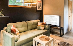 A living room with a sofa, a small table, a TV, and a lamp. - 2 bedroom beautiful home in Kopalino (Kopalino)