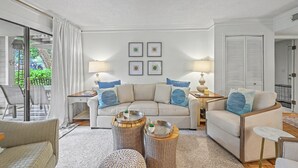 A living room with a sofa, two side tables, a coffee table, and a chair. - Beyond Measure by Sandpiper | Near Beach (Seabrook Island)