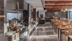 A modern restaurant with a long counter, marble flooring, and wooden tables. - Mogan Dreamlohas Sunrise Resort Hotel (Huzhou)
