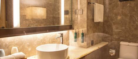 A modern bathroom with a marble sink, a mirror, a toilet, and a butterfly wall decoration.