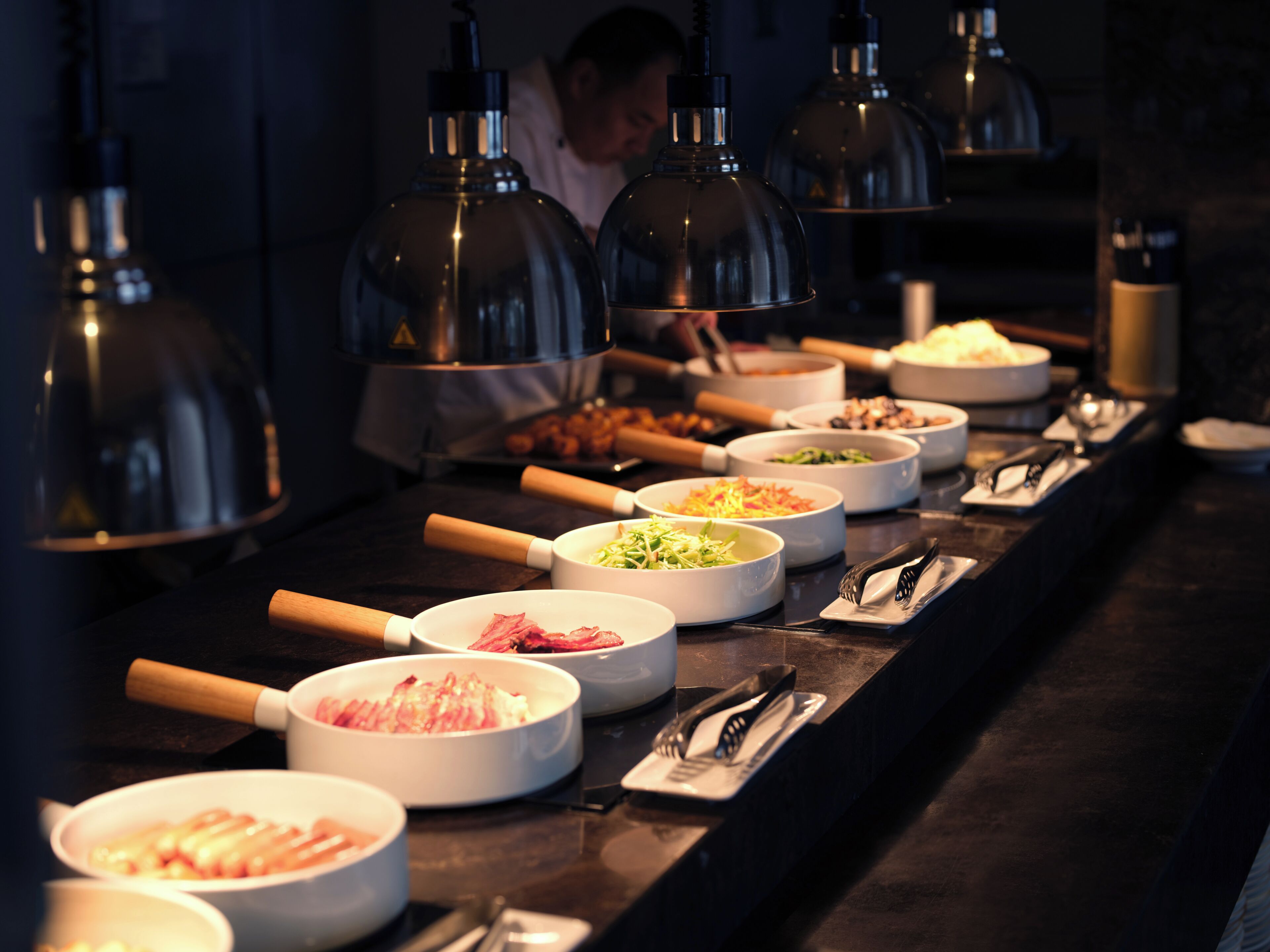 A buffet with various dishes and utensils.