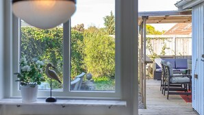 A view through a window into a patio area with outdoor furniture and a wooden deck. - Nice home in Smygehamn with WiFi (Smygehamn)