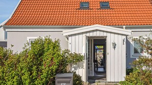 A building with a red-tiled roof, a white facade, and a small entrance with a door and window. - Nice home in Smygehamn with WiFi (Smygehamn)
