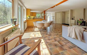 Eine geräumige Küche mit Essbereich, einer Couch und Blick ins Freie.