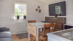A room with a wooden table, chairs, a radiator, a window with plants, and a mirror on the wall. - Cozy home in Gärds Köpinge with WiFi (Gärds Köpinge)