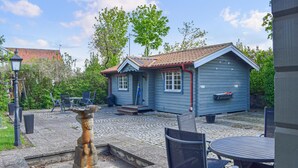 A small blue building with a tiled roof, a flag, and a parking sign. - Cozy home in Gärds Köpinge with WiFi (Gärds Köpinge)