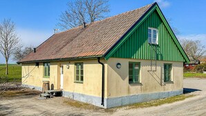 A single-story building with a sloped roof, green trim, and a small porch. - Amazing home in Tomelilla with WiFi (Tomelilla)