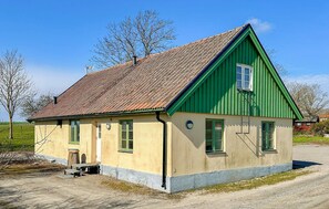 A single-story building with a sloped roof, green trim, and a small porch. - Amazing home in Tomelilla with WiFi (Tomelilla)