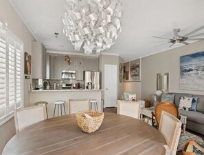 Eine moderne Küche mit Essbereich, Deckenventilator und einer großen abstrakten Leuchte.