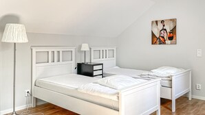 Ett sovrum med en säng, sängbord, en lampa och en tavla på väggen.