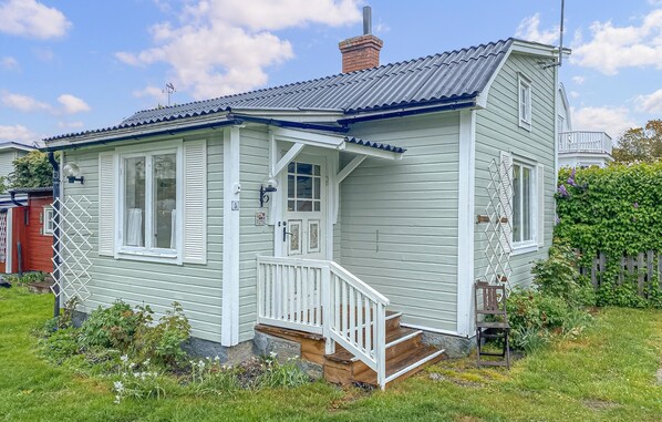 Ein eingeschossiges Haus mit Veranda, Schornstein und der Hausnummer 5.