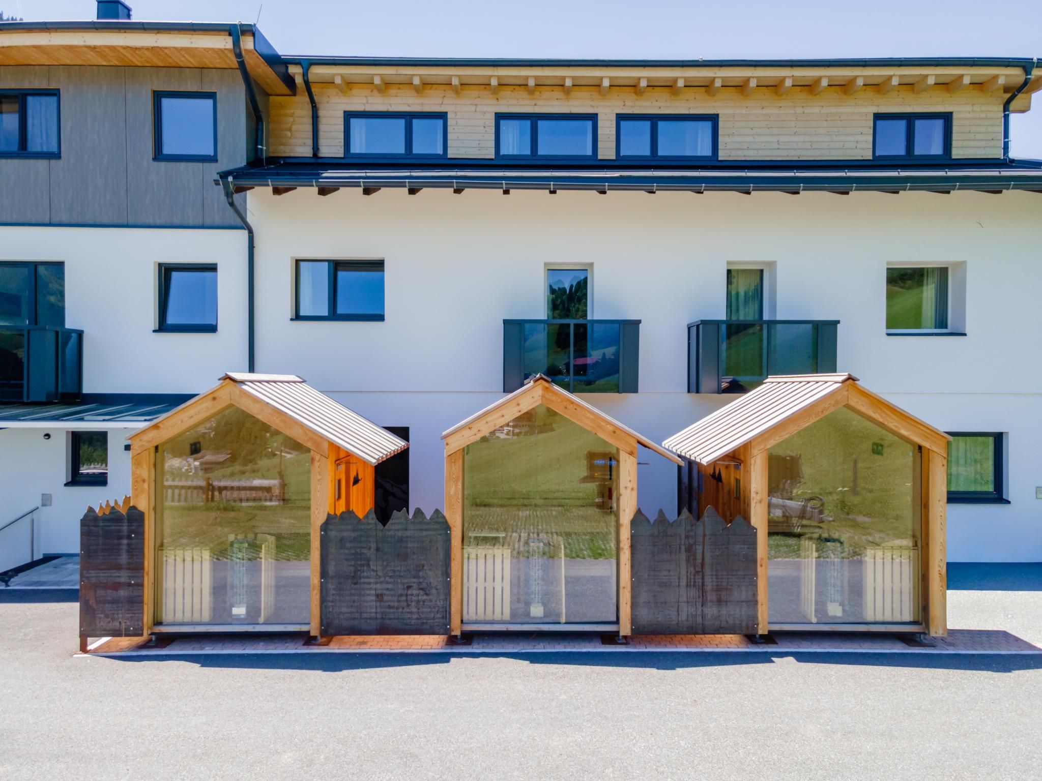 Un edificio moderno con tres estructuras de madera que parecen pequeñas casas.