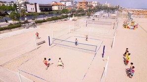 A beach volleyball court with net, players, and spectators. - Holiday apartment with wooden veranda (Viserba di Rimini)
