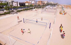 A beach volleyball court with net, players, and spectators. - Holiday apartment with wooden veranda (Viserba di Rimini)