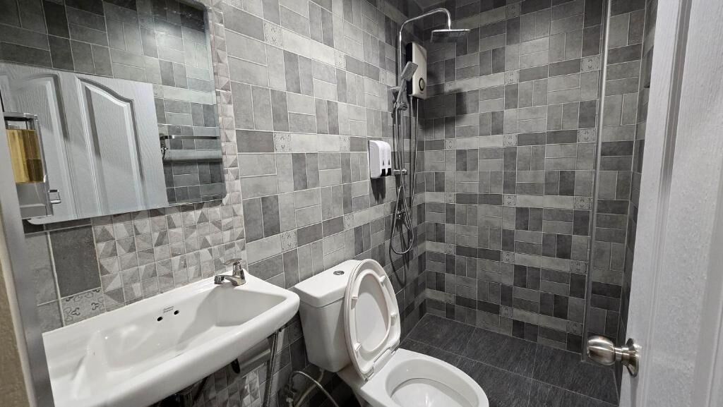 Un baño con inodoro, lavabo y ducha.