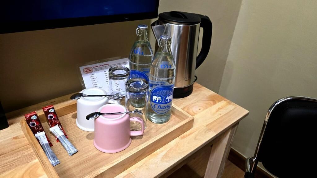 Une table en bois avec une tasse, des bouteilles, une bouilloire et une cuillère.
