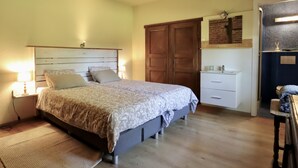 A bedroom with a bed, bedside lamps, a wardrobe, a small desk, and a bathroom with a mirror and sink. - Large cottage near the Fagnes and Francorchamps. (Francorchamps)