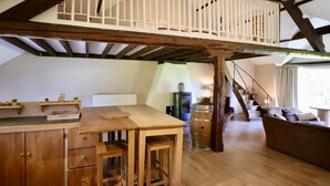 A loft-style room with a wooden desk, a barrel, and a staircase. - Large cottage near the Fagnes and Francorchamps. (Francorchamps)