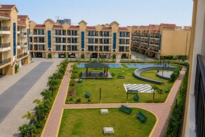 A hotel courtyard with a pool, benches, and a gazebo. - Aerohub Suites: Himalayan Foothills Escape Cozy 1BHK in Zirakpur, NearChandigarh (Zirakpur)