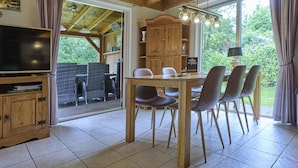 A wooden dining area with a table and chairs, a television, and a sign reading 'villa for you'. - Home in a private park with a spacious garden (Epe)
