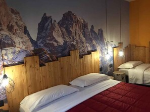 A room with a wooden headboard, a bed with white bedding, and a mountain mural on the wall. - Holiday apartment with mountain view and terrace (Cavedago)