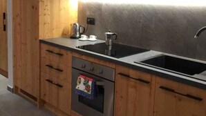 Une cuisine moderne avec des meubles en bois, un four à micro-ondes, une cuisinière et un évier.