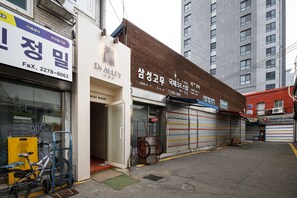A street view with closed storefronts, a bicycle, and a building with a sign in a foreign language. - Di Alley Jongro (Seoul)