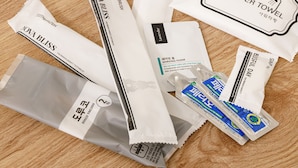 Un assortiment de produits de toilette comprenant une serviette de bain, de la mousse à raser et des brosses à dents.
