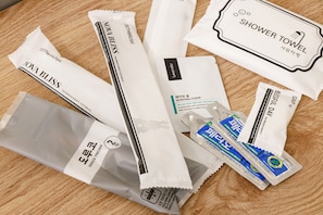 Valikoima hygieniatuotteita, kuten suihkupyyhe, partavaahto ja hammasharjat.