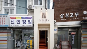 Un bâtiment avec une enseigne indiquant « D’ Alley » et une entrée marquée « mini-hôtel ».
