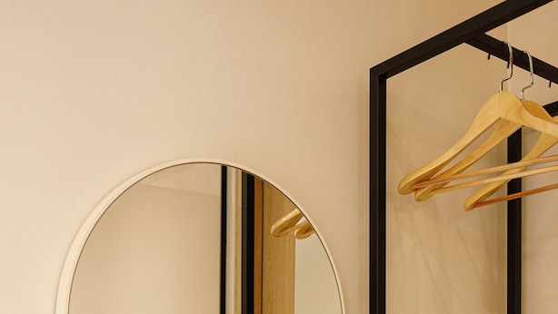 Un miroir avec un cadre en bois, une table en bois et un cintre en bois.